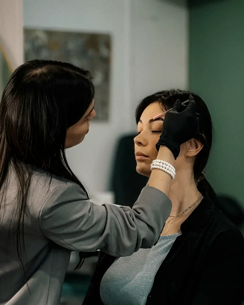 Especialista en cejas atendiendo a una clienta en su estudio