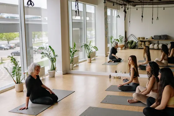 Instructora dirigiendo una clase de yoga en un estudio con luz natural