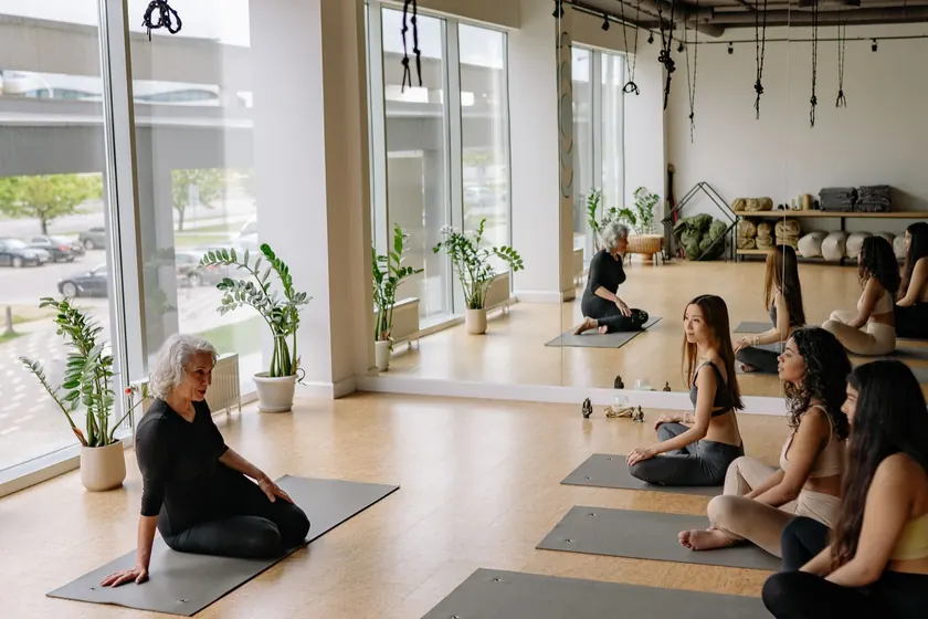 Instructora dirigiendo una clase de yoga en un estudio con luz natural